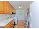 Bright laundry area featuring a stainless steel fridge, a laundry sink, wood cabinets, and a front load washer at 170 Majesty Ln, Fayetteville, GA 30215