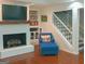 Cozy living room features a brick fireplace, hardwood floors, and a comfortable blue chair at 170 Majesty Ln, Fayetteville, GA 30215