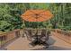 Deck with outdoor dining set under an umbrella, surrounded by trees and flower boxes at 170 Majesty Ln, Fayetteville, GA 30215