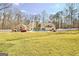 Lush backyard view featuring an expansive lawn, patio, pool, and mature trees at 106 Robinson Bend Trl, Peachtree City, GA 30269