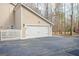 Side view of a clean, white garage door featuring carriage accents, white trim, and a neatly paved driveway at 106 Robinson Bend Trl, Peachtree City, GA 30269
