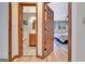 Hallway view of the primary bathroom and bedroom with warm wood trim, tiled floors, and painted blue walls at 106 Robinson Bend Trl, Peachtree City, GA 30269