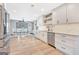 A modern kitchen with stainless steel appliances, white cabinetry, and hardwood floors leading into the dining area at 106 Robinson Bend Trl, Peachtree City, GA 30269