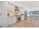 Modern kitchen with stainless steel appliances, white cabinetry, and hardwood floors with view to dining area at 106 Robinson Bend Trl, Peachtree City, GA 30269