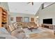 Inviting living room featuring a large sectional sofa, stone fireplace, and vaulted ceilings, perfect for entertaining at 106 Robinson Bend Trl, Peachtree City, GA 30269