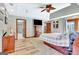 Large main bedroom with hardwood floors, ceiling fan, TV, and doors leading to the bathroom and sitting area at 106 Robinson Bend Trl, Peachtree City, GA 30269