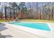Backyard pool with hot tub and lounge seating surrounded by a lawn and treeline at 106 Robinson Bend Trl, Peachtree City, GA 30269