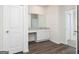 Bathroom vanity area with granite countertop, white cabinetry, and wood-look flooring at 909 Hesston Dr, Locust Grove, GA 30248
