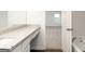 Bathroom vanity with stone countertop, tub with chrome faucet, and an open door to a bedroom at 1048 Claas Way, Locust Grove, GA 30248