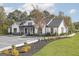 Stunning modern farmhouse exterior with white siding, black accents, and lush landscaping at 1048 Claas Way, Locust Grove, GA 30248