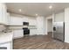 Well-lit kitchen with stainless steel appliances, white cabinets, and sleek, granite countertops at 1048 Claas Way, Locust Grove, GA 30248