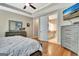 Main bedroom boasts tray ceiling, ceiling fan, hardwood flooring, TV, dresser, and en suite bathroom at 339 Cottonwood Cir, Peachtree City, GA 30269