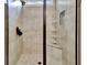 Shower featuring glass doors, tiled walls, a shower head and a built-in shelf for storage at 339 Cottonwood Cir, Peachtree City, GA 30269