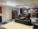 A basement with a two-seat sofa and a home theater projector mounted on the ceiling at 260 Millbrook Village Dr, Tyrone, GA 30290