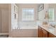 Bathroom featuring a soaking tub, window, and vanity with ample counter space at 260 Millbrook Village Dr, Tyrone, GA 30290