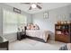 A bedroom with a ceiling fan, window, rug, and furniture against a neutral painted wall at 260 Millbrook Village Dr, Tyrone, GA 30290