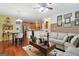 Cozy living room showcasing hardwood floors, an inviting sofa, and seamless flow to the kitchen at 260 Millbrook Village Dr, Tyrone, GA 30290