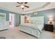 Comfortable main bedroom featuring a tray ceiling, carpet, and en-suite bathroom access at 260 Millbrook Village Dr, Tyrone, GA 30290