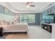 Spacious main bedroom with a large window, tray ceiling, plush carpet, and a TV at 260 Millbrook Village Dr, Tyrone, GA 30290