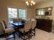 Dining room featuring a large window, neutral walls, a stylish chandelier, and views into the kitchen at 100 Kent Rock Rd, Loganville, GA 30052