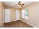 Neutral bedroom featuring a window, fan, and two doors, enhancing accessibility and comfort at 5797 Strathmoor Manor Cir, Lithonia, GA 30058