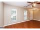Bright living room featuring wood floors, two windows, and a white door at 5797 Strathmoor Manor Cir, Lithonia, GA 30058