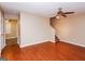 Living room featuring wood floors, a ceiling fan, access to stairs, and a view into another room at 5797 Strathmoor Manor Cir, Lithonia, GA 30058