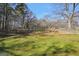 Large backyard with a chain link fence and mature trees at 74 Price W Dr, Locust Grove, GA 30248