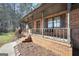 Welcoming covered front porch with brick siding and a charming entrance, complete with Georgia Bulldogs decor at 74 Price W Dr, Locust Grove, GA 30248