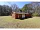 Exterior view of the outbuilding, featuring garage and entry doors, on a large lot with mature trees at 74 Price W Dr, Locust Grove, GA 30248