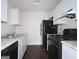 Clean kitchen with white cabinets, granite counters, and black appliances at 905 Pine Tree Trl, South Fulton, GA 30349