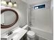 The bathroom has a white vanity and tub/shower with a unique, decorative, framed circular mirror at 1280 Pinyon Pl, Lawrenceville, GA 30043