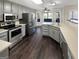 The kitchen has stainless steel appliances, light countertops, gray cabinets, and dark wood flooring at 1280 Pinyon Pl, Lawrenceville, GA 30043