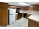 Traditional kitchen featuring wood cabinets, white refrigerator, and black appliances at 1280 Pinyon Pl, Lawrenceville, GA 30043