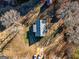 Aerial view of the home on a lot with mature trees and gravel driveway at 550 Stateline Rd, Bowdon, GA 30108