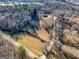 Aerial view of a home on lot with grassy area, mature trees, gravel driveway and a creek at 550 Stateline Rd, Bowdon, GA 30108