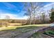 A backyard with a small hill, grass, and scattered trees at 550 Stateline Rd, Bowdon, GA 30108