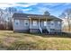 Inviting single-story home featuring a cozy front porch, well-maintained lawn and blue sky at 550 Stateline Rd, Bowdon, GA 30108
