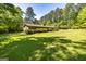 Expansive backyard with lush lawn, mature trees, and a glimpse of the rear of the brick home, promising outdoor enjoyment at 160 Pine Trail Rd, Fayetteville, GA 30214