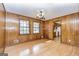 Cozy dining room with wood-paneled walls, chandelier lighting and open pass-through to kitchen at 160 Pine Trail Rd, Fayetteville, GA 30214