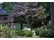 Exterior view of lush yard with flowering trees and bushes, framed by trees at 160 Pine Trail Rd, Fayetteville, GA 30214