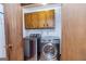Modern laundry room with stainless steel washer and dryer units with overhead cabinet storage at 160 Pine Trail Rd, Fayetteville, GA 30214