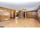 Open-concept living area with a central brick fireplace, wood paneling, and light hardwood floors at 160 Pine Trail Rd, Fayetteville, GA 30214