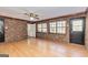 Large living room showcasing brick accent wall, windows and hardwood floors at 160 Pine Trail Rd, Fayetteville, GA 30214