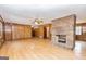 Spacious living room features a brick fireplace, wood-paneled walls and bright, light hardwood floors at 160 Pine Trail Rd, Fayetteville, GA 30214