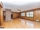 Spacious living room with hardwood floors, wood paneling, a brick fireplace, and natural light from large windows at 160 Pine Trail Rd, Fayetteville, GA 30214