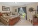 Cozy bedroom with a wooden bed frame, soft carpet, and ample natural light from the window at 925 Champions Way, Mcdonough, GA 30252