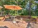 Wooden deck area with table, chairs, umbrella and view of wooded backyard at 925 Champions Way, Mcdonough, GA 30252