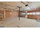 Unfinished basement with exposed ceiling and a roll-up door at 4847 Royal Dr, Duluth, GA 30096