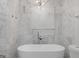 Luxurious bathroom with marble tiling and a free standing modern bathtub at 859 Kings Grant Nw Dr, Atlanta, GA 30318